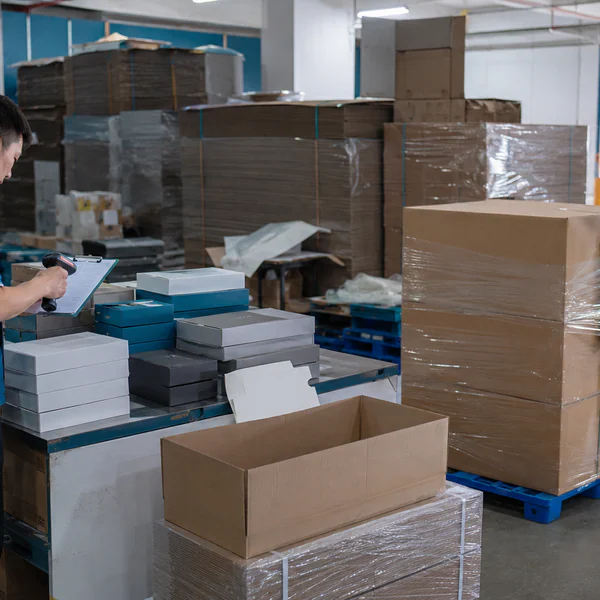 Workers packing finished boxes into master cartons