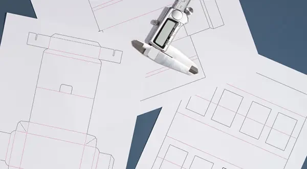Technical packaging die-line blueprint on a review board